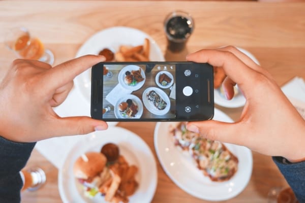 influencer som tar bilde av mat med mobil