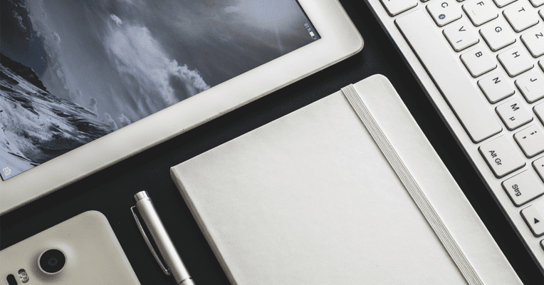 et nærbilde av et hvitt tastatur, mobil og nettbrett