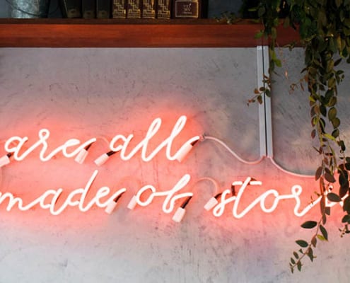 Neonskilt med teksten "We are all made of stories"