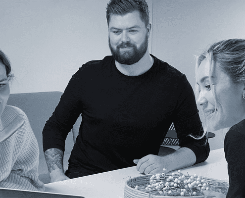 Tre stk rundt et bord som ser på en pc