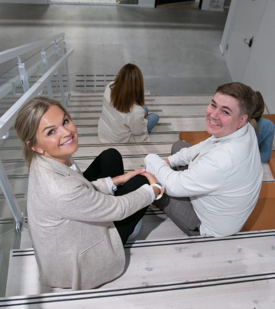 Ansatte sitter i trappen. Foto