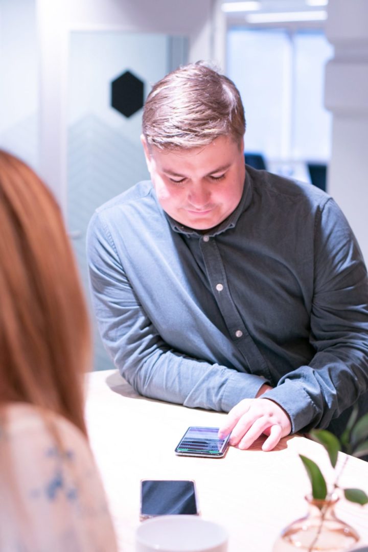 Digital markedsfører og markedssjef Sindre ser på mobilen